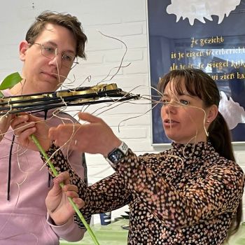 Bloemist ondernemer met twee medewerkers achter laptop in bloemenwinkel